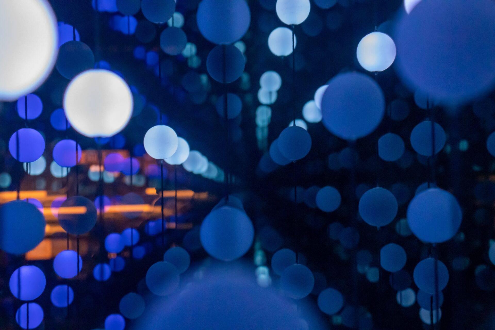 Décoration de rue illuminée de nuit avec guirlandes lumineuses bleues et blanches créant une ambiance festive urbaine