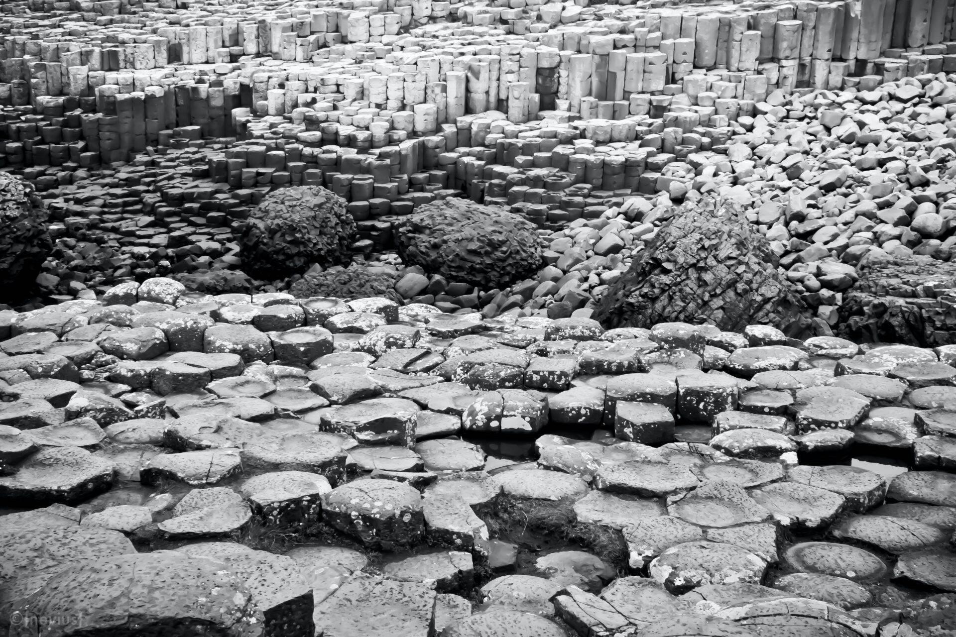 Formations de colonnes de basalte hexagonales grises en plan rapproché sur une plage rocheuse