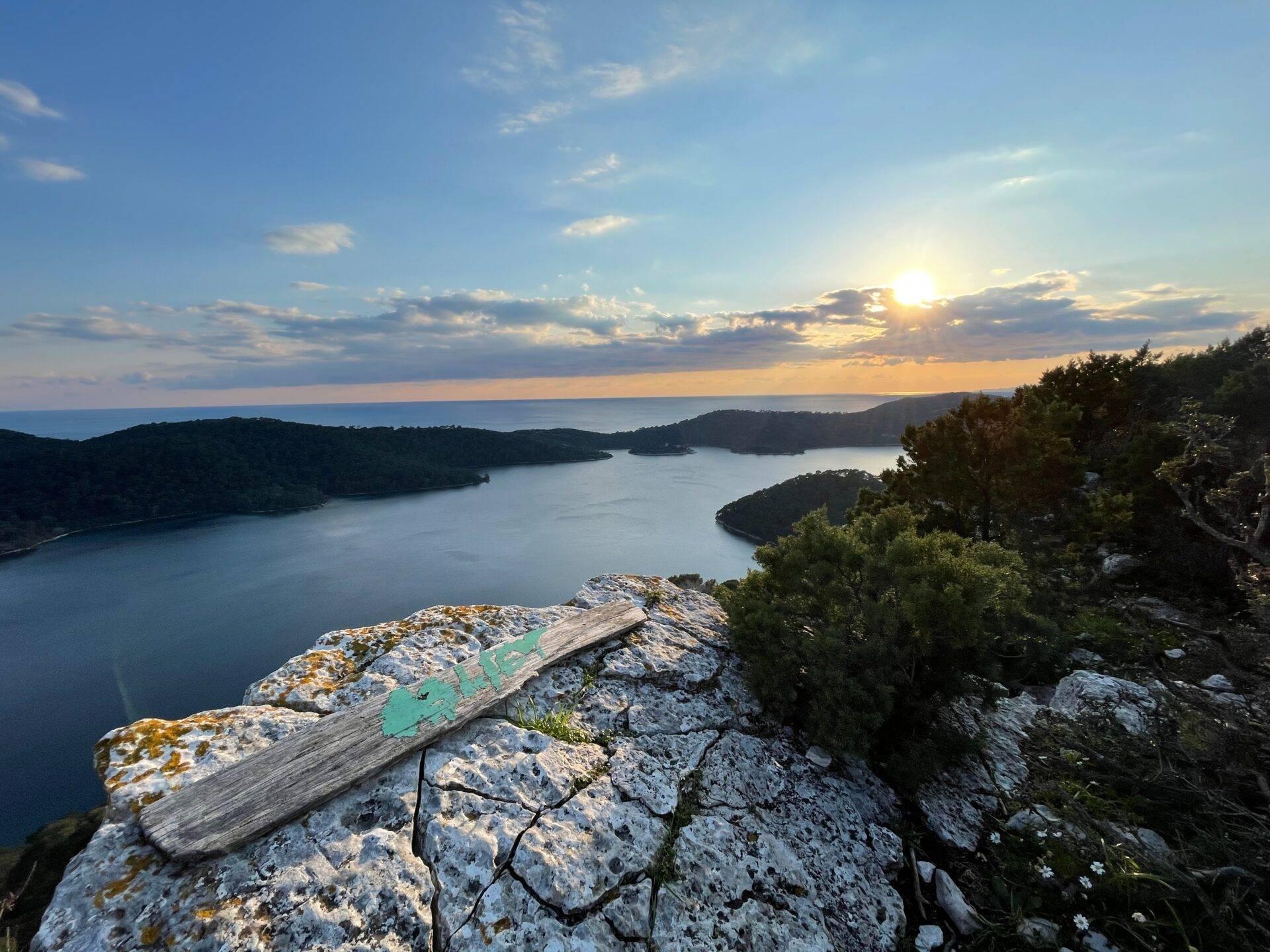 Vue panoramique au coucher de soleil sur un littoral méditerranéen avec baies boisées et rochers côtiers