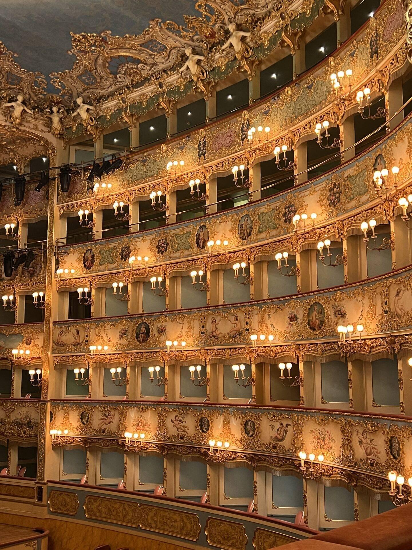 Intérieur somptueux d’un théâtre baroque avec balcons dorés ornés et appliques lumineuses