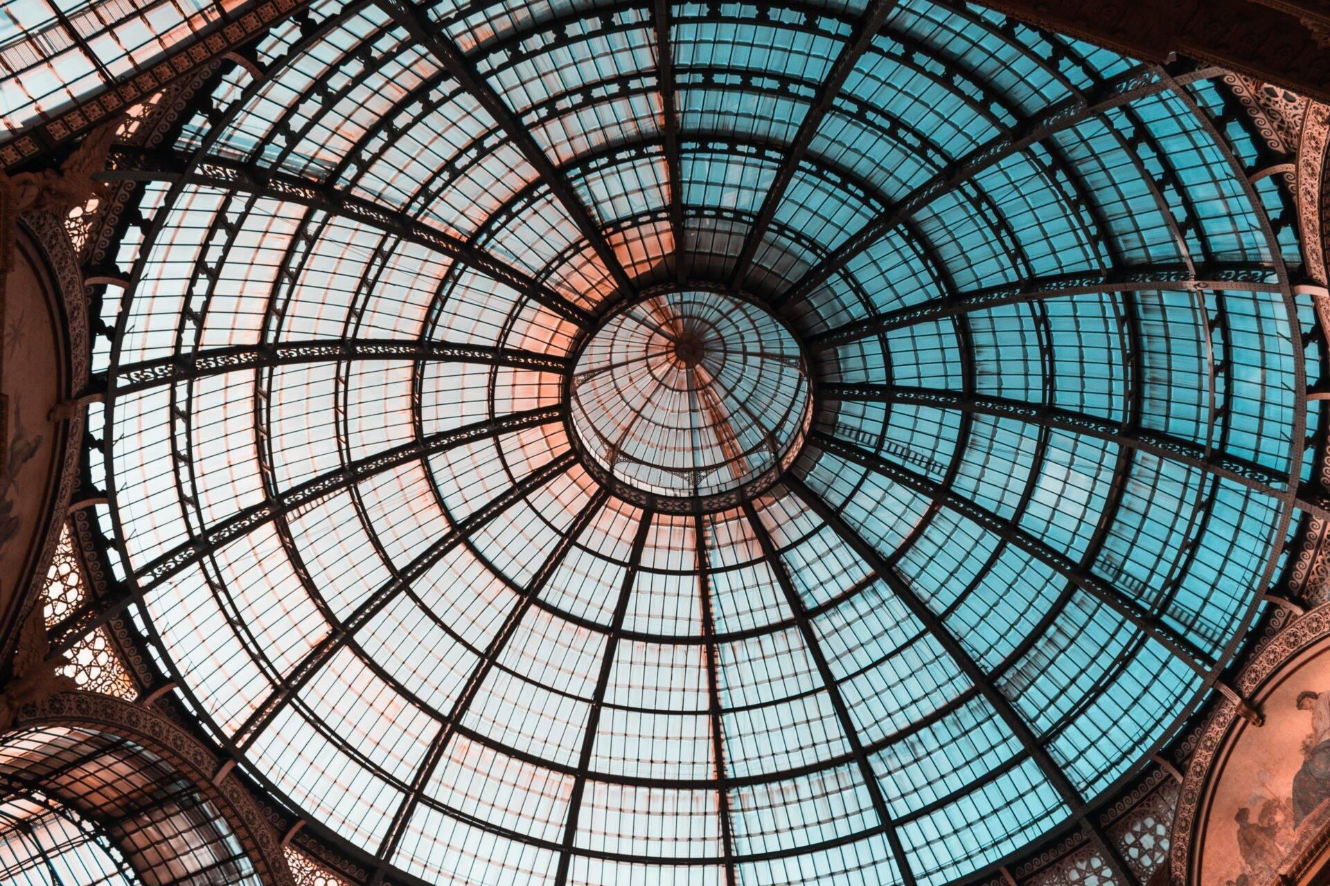 Vue zénithale d’une verrière dome architecturale aux carreaux géométriques avec structure métallique ornementale et éclairage naturel