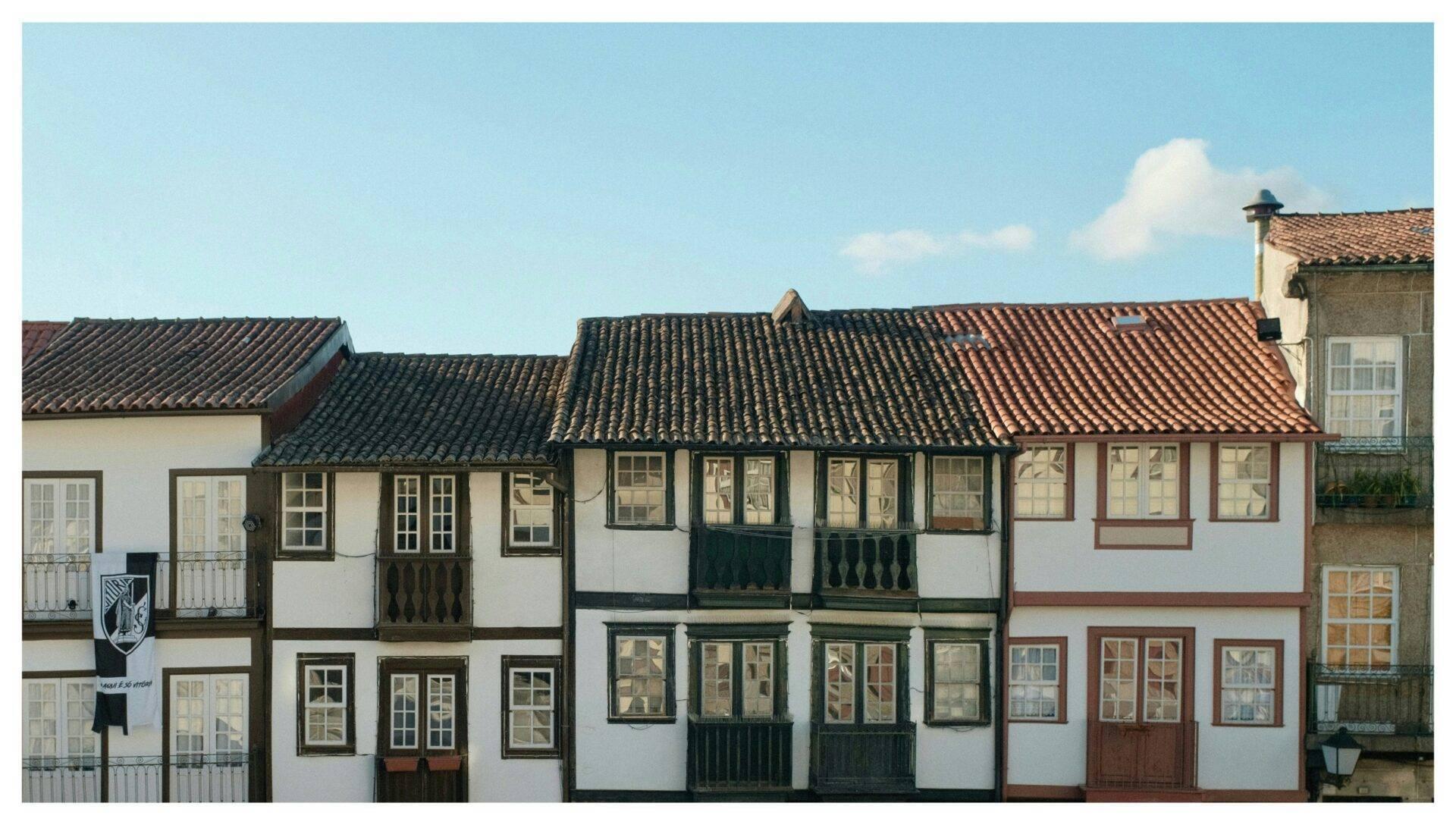 Rangée de maisons coloniales traditionnelles aux façades blanches et noires avec toits de tuiles terracotta