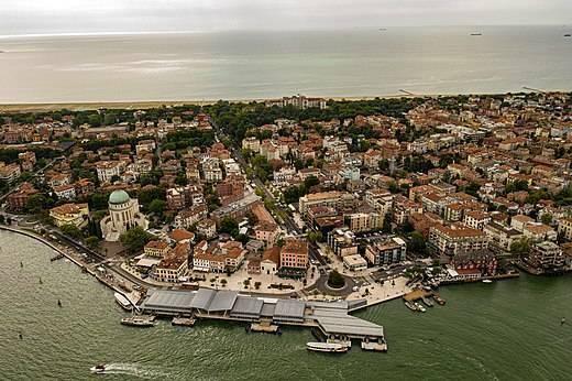 Vue aérienne d’une ville côtière européenne avec architecture densifiée, waterfront pittoresque et bateau de transport maritime