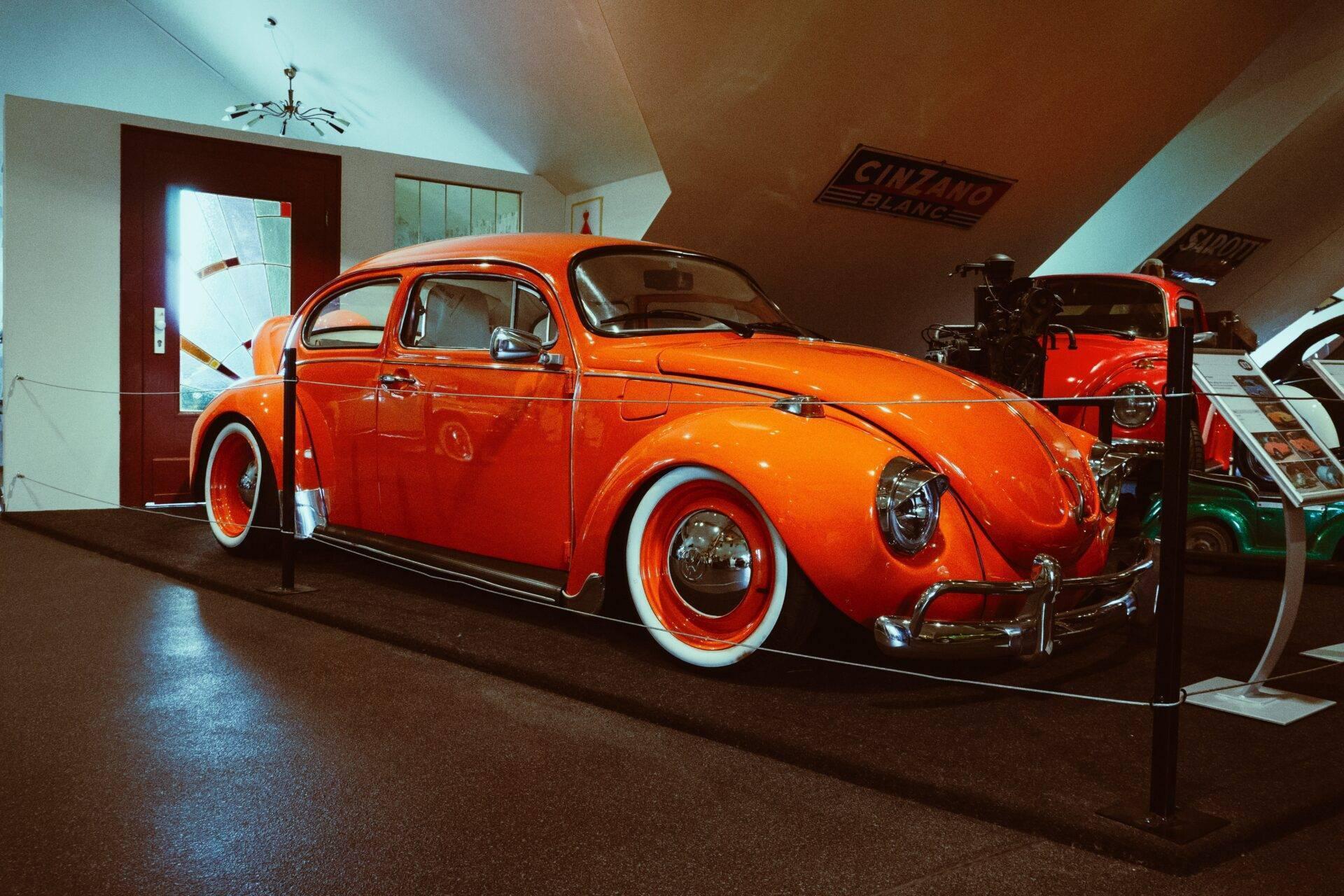 Une Volkswagen Coccinelle rouge restaurée exposée dans un musée automobile couvert