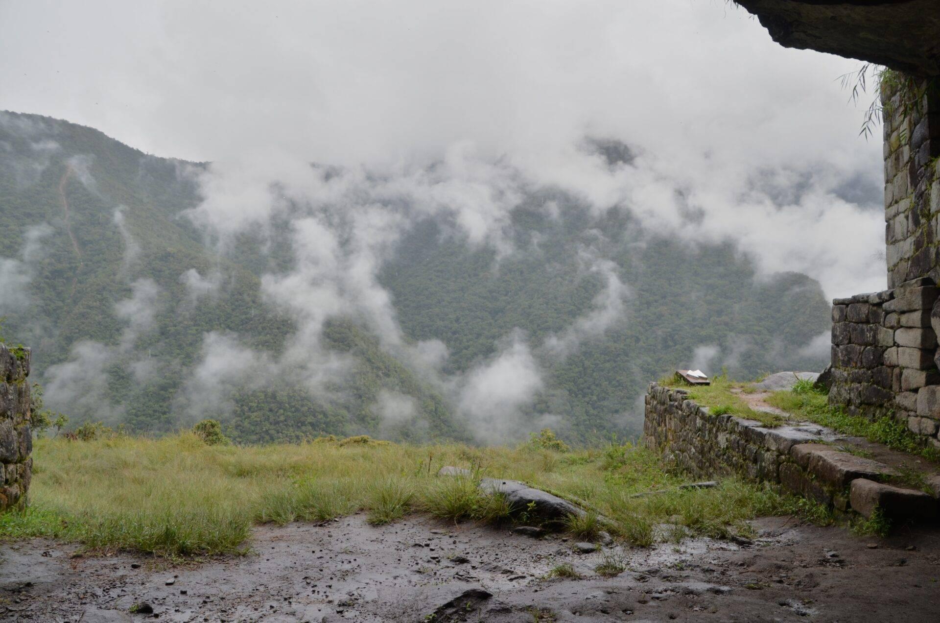 Vue depuis les ruines d’un temple en pierre sur des montagnes couvertes de forêt dense et de brouillard épais