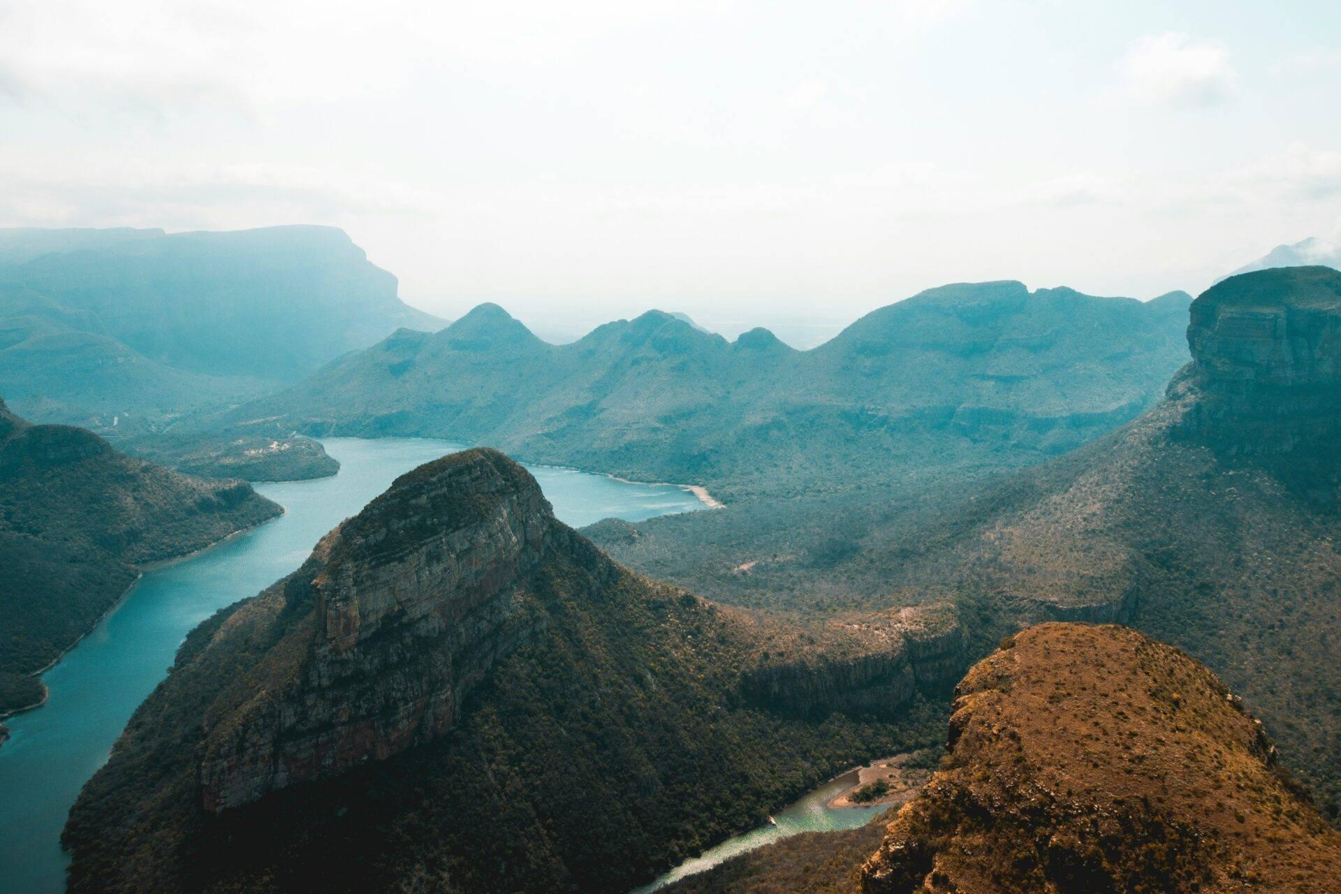 Vue aérienne de lacs turquoise entourés de montagnes boisées et de formations rocheuses escarpées