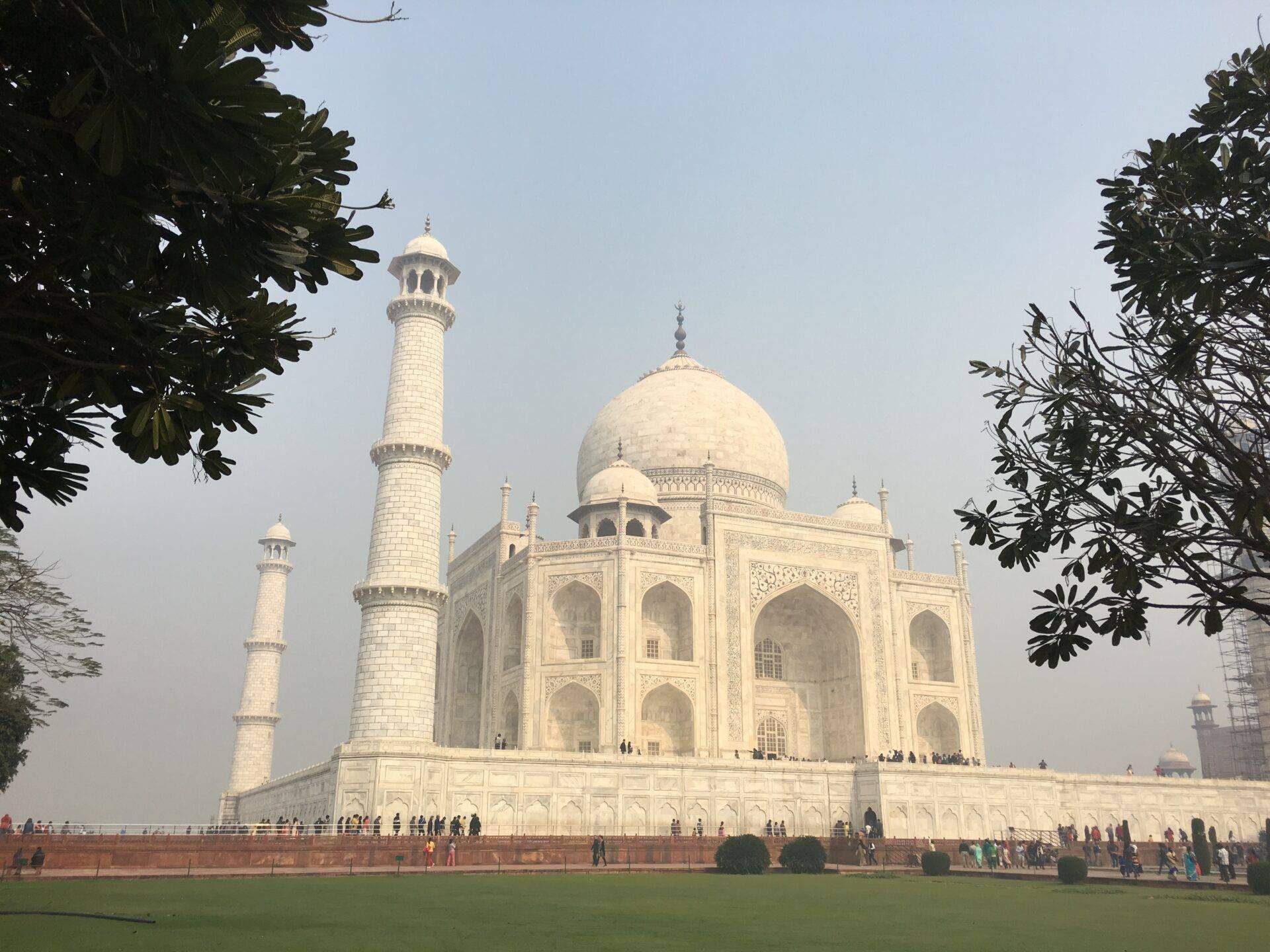 Un monument blanc emblématique avec dôme et minarets, entouré de visiteurs sur une vaste esplanade