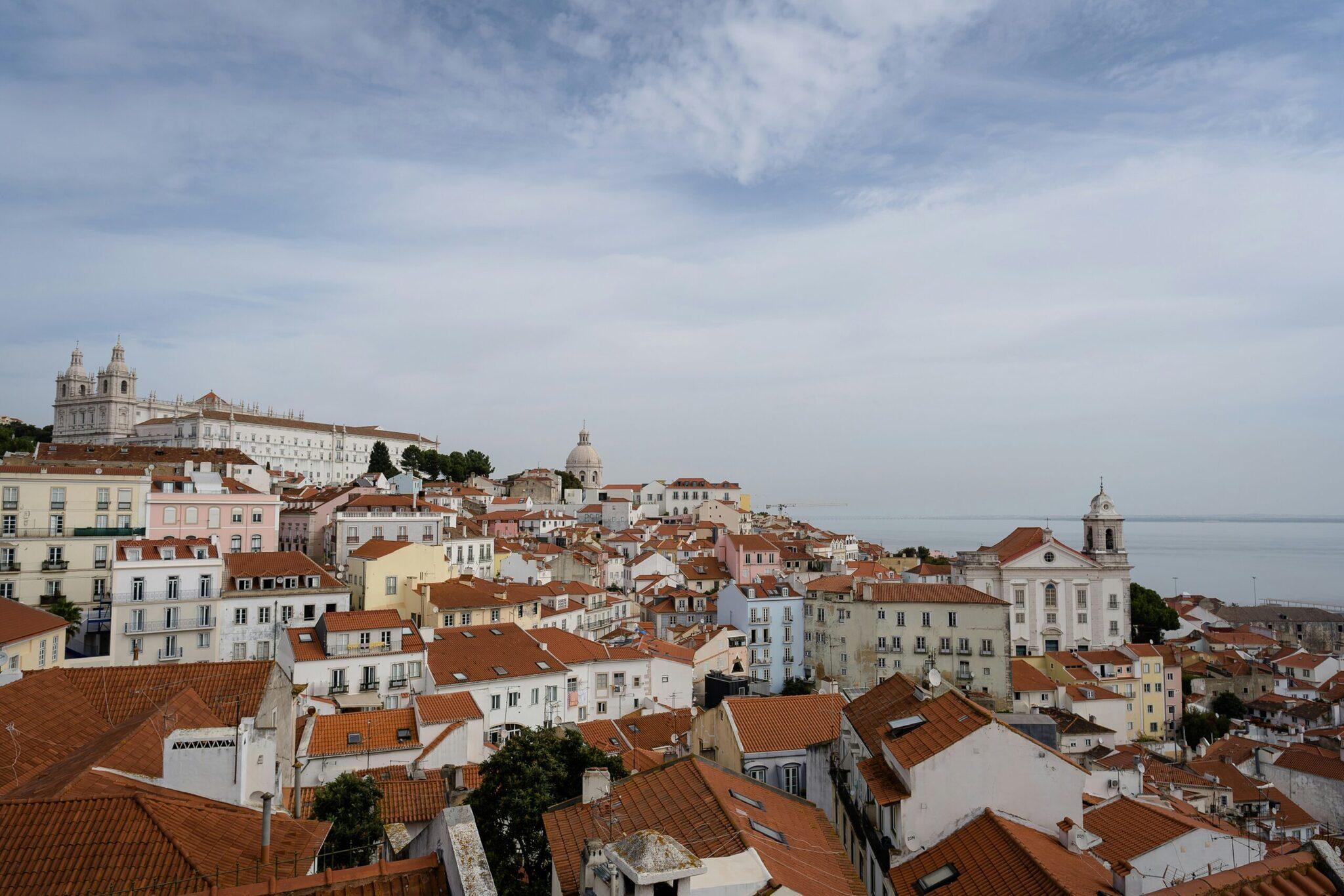 Vue panoramique d’une ville historique européenne aux toits de tuiles rouges et églises dominantes sous un ciel nuageux