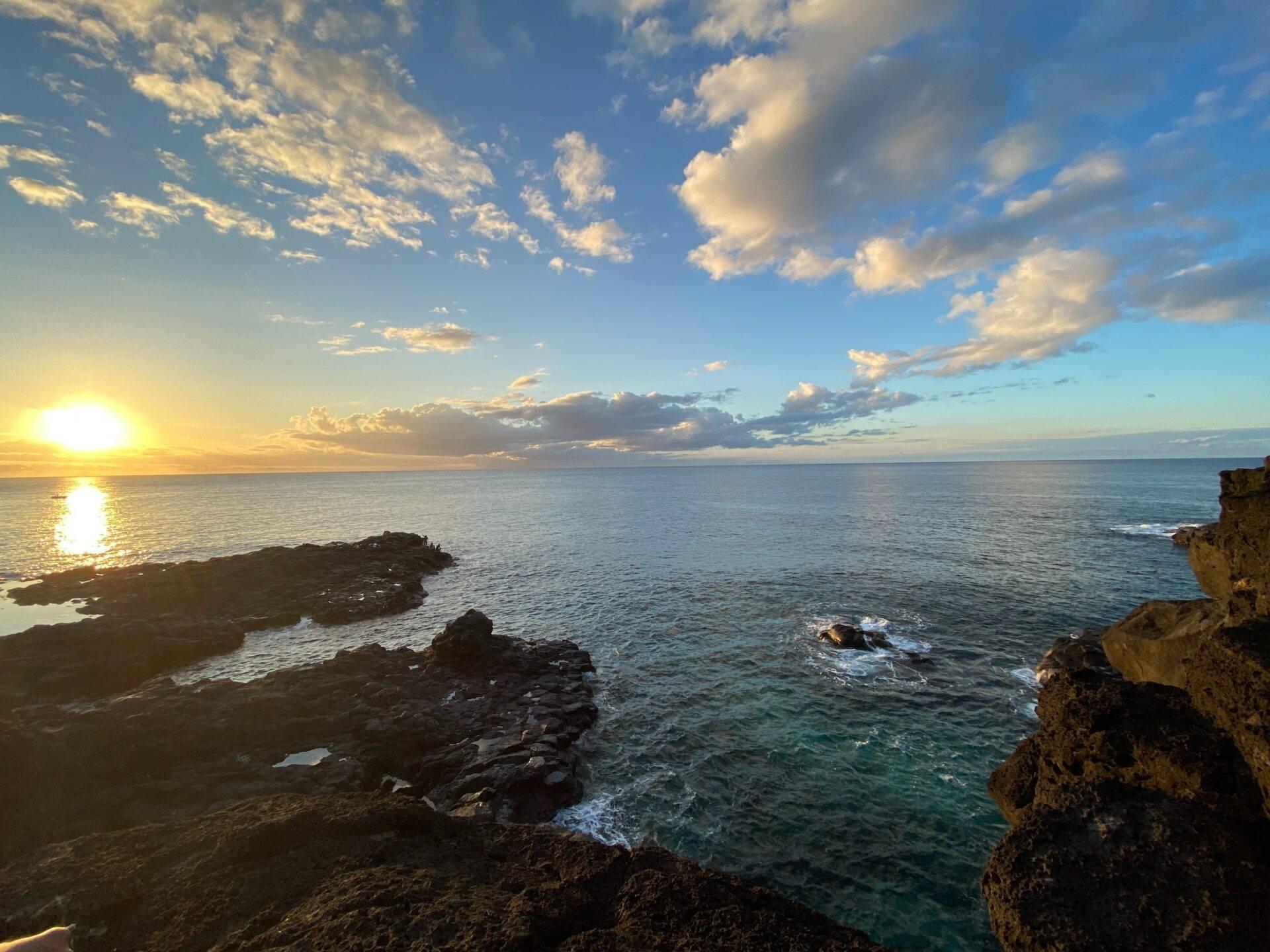 Coucher de soleil sur une côte rocheuse de l’océan Indien avec ciel nuageux doré et eaux turquoise