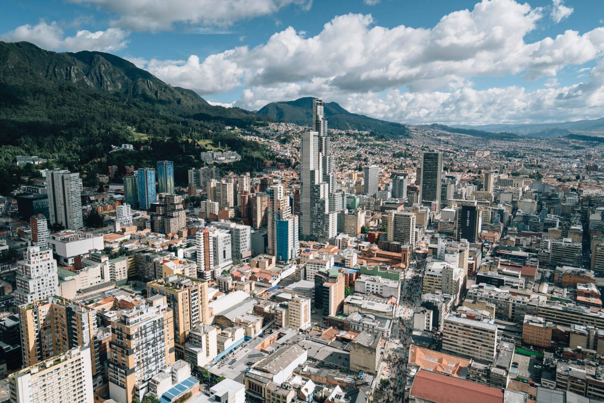 Vue aérienne d’une grande ville andine entourée de montagnes verdoyantes avec gratte-ciel modernes et architecture coloniale