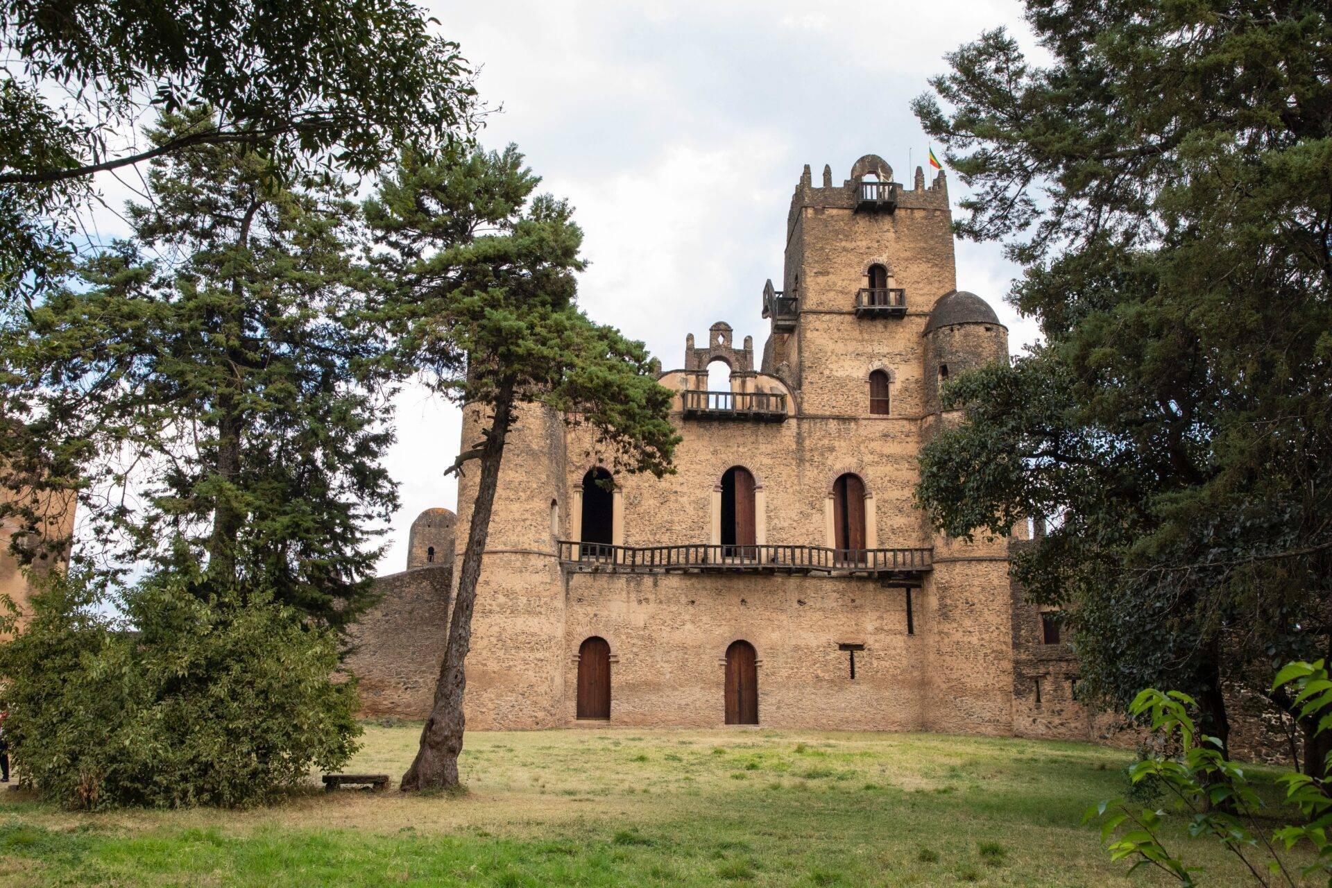 Forteresse en pierre avec tours crénelées entourée de végétation luxuriante en Éthiopie