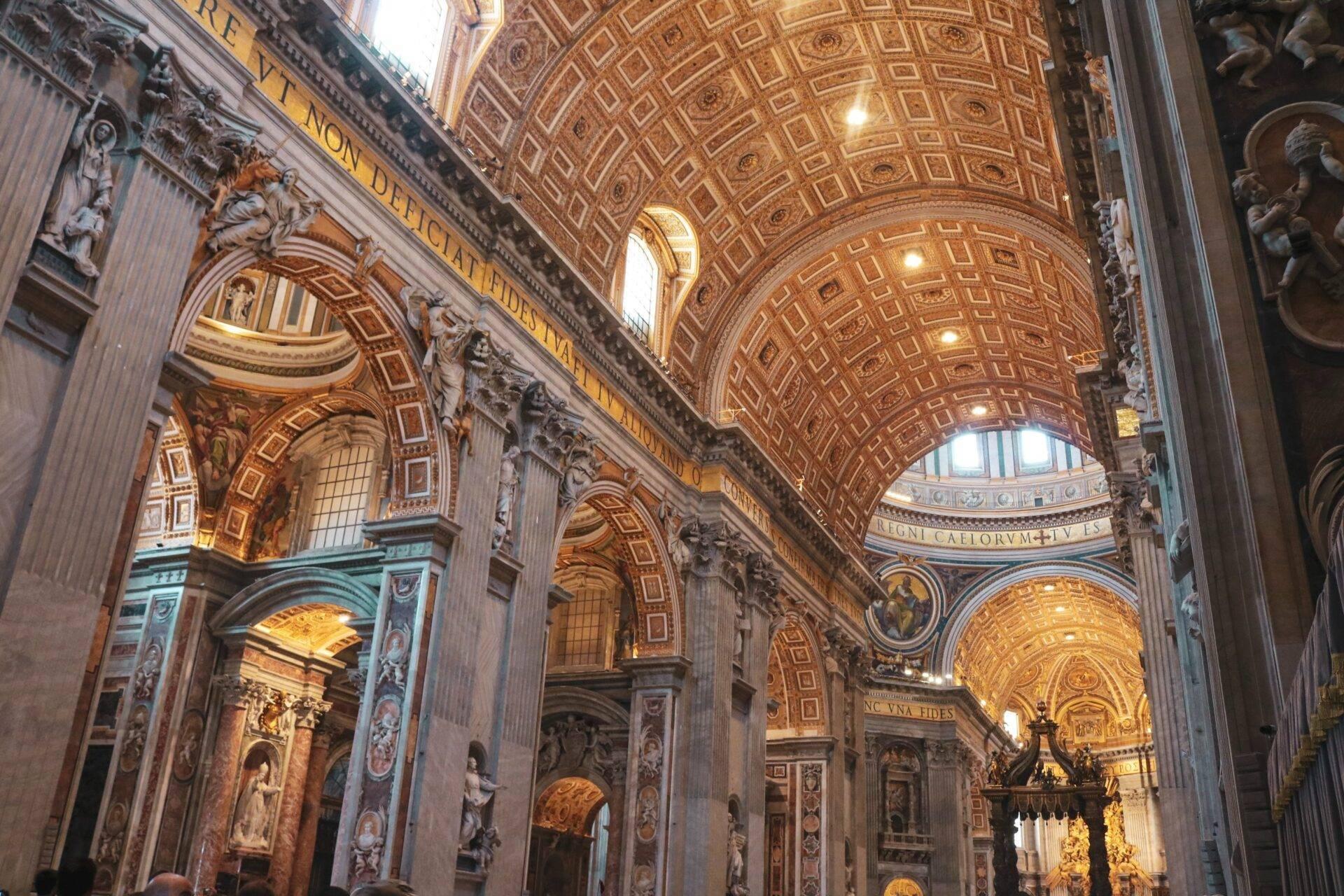 Intérieur majestueux d’une basilique baroque avec voûtes dorées, colonnes ornées et sculptures religieuses