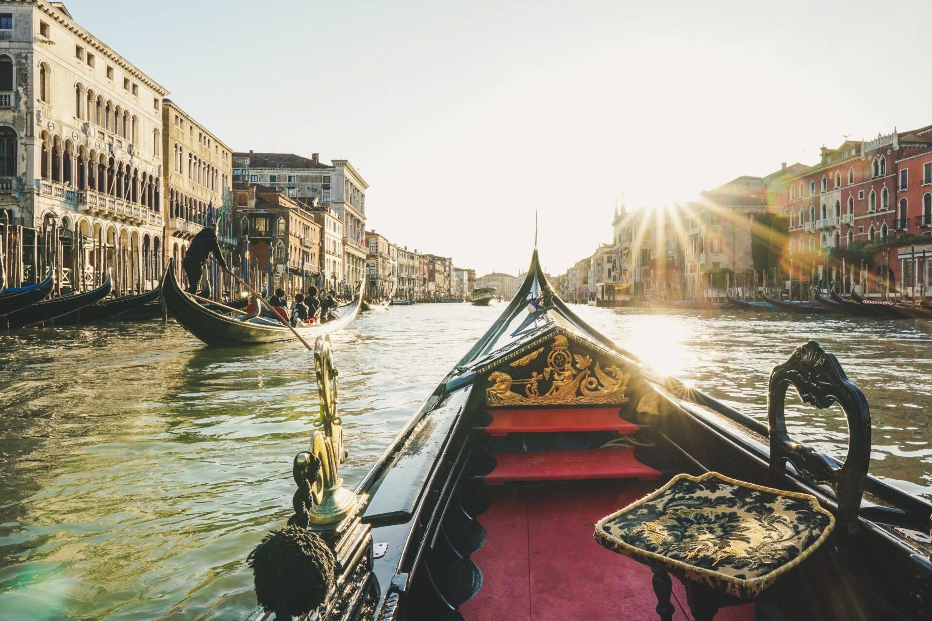Vue depuis une gondole vénitienne décorée naviguant sur le Grand Canal avec palais historiques et sunlight
