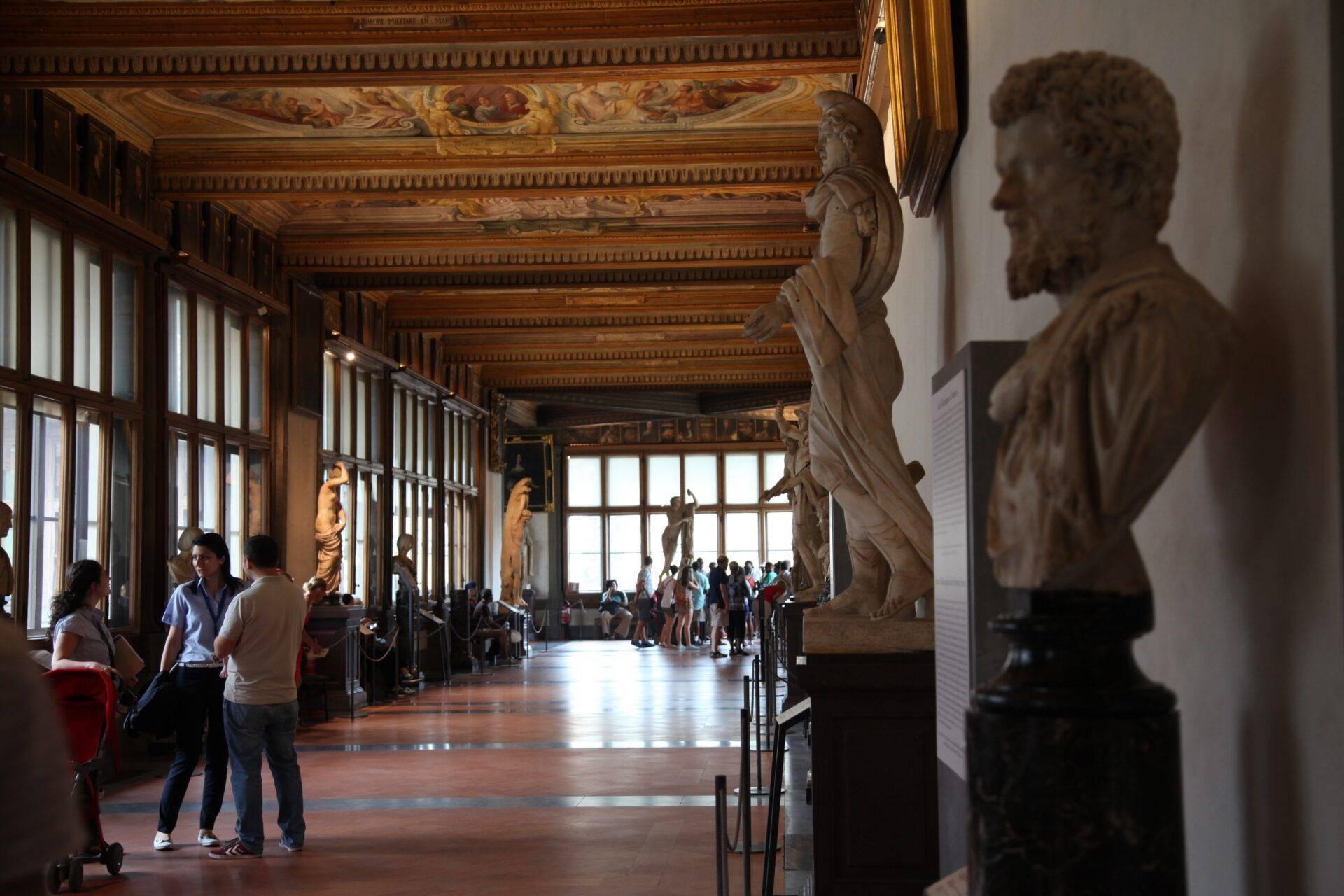 Galerie de musée italienne avec statues antiques, plafond peint ornementé et visiteurs admirant les sculptures