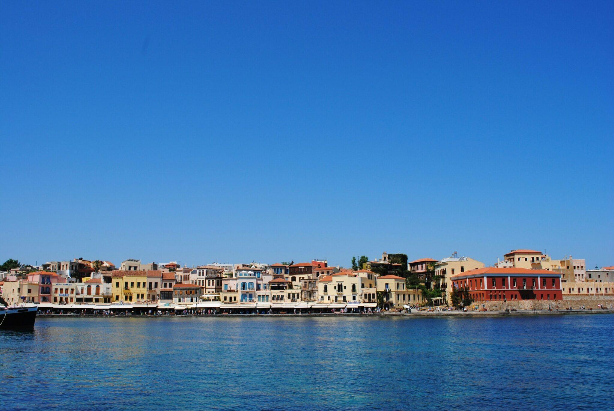 Colourful facade of a Mediterranean harbour town with traditional buildings overlooking a turquoise sea