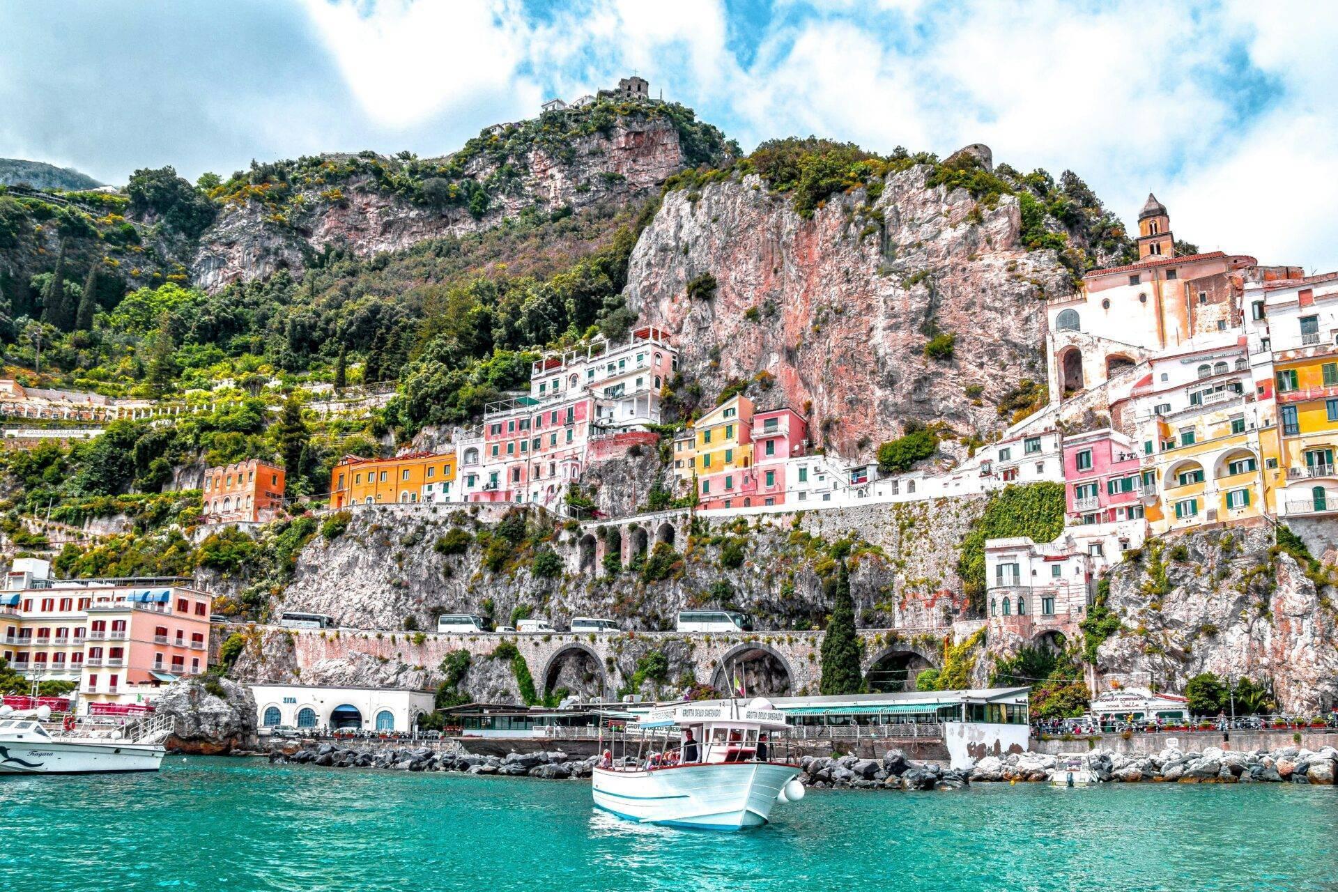 Un village côtier coloré accroché aux falaises rocheuses avec bateaux amarrés en méditerranée