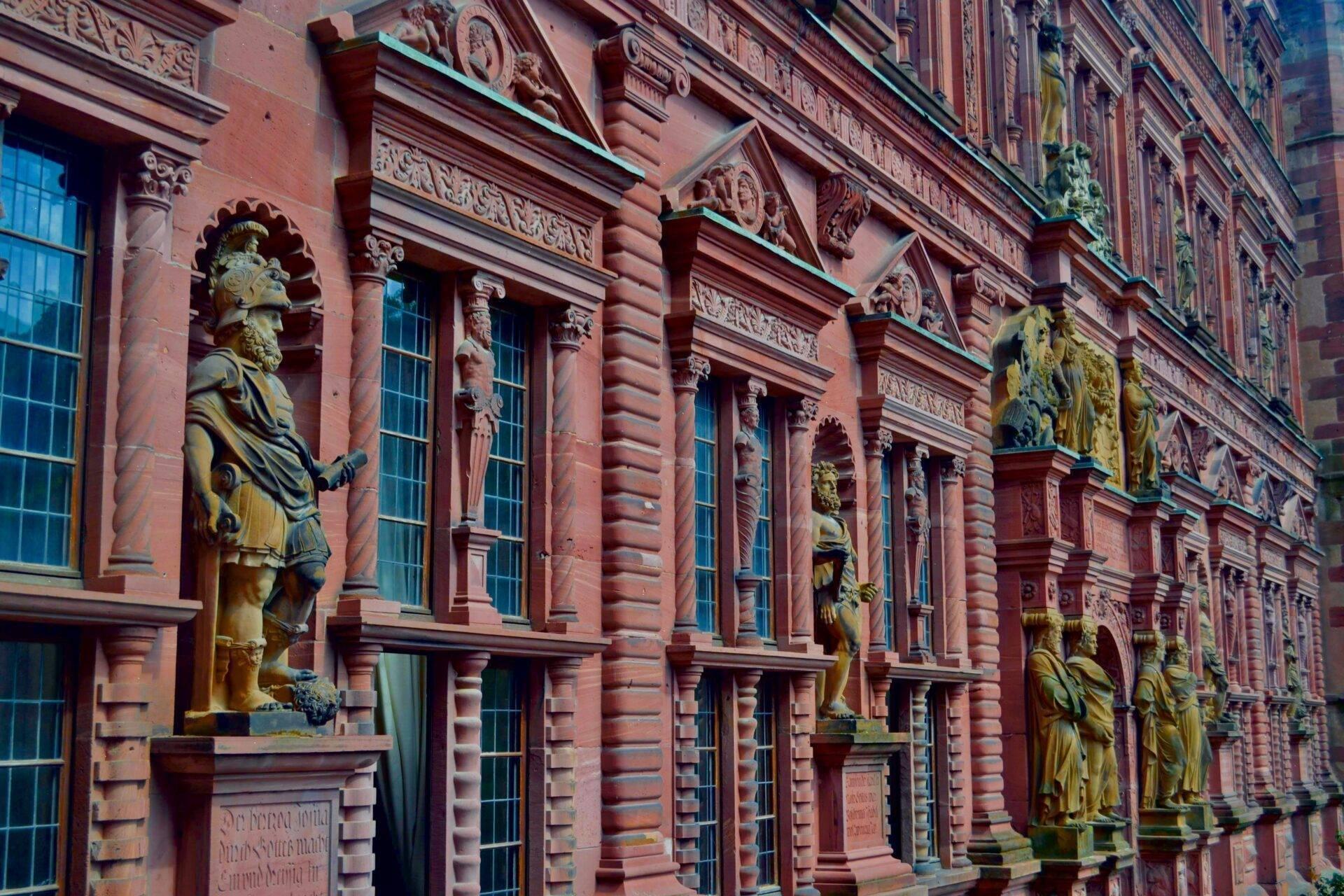 Façade ornée en brique rouge avec statues dorées et colonnes sculptées, architecture historique allemande