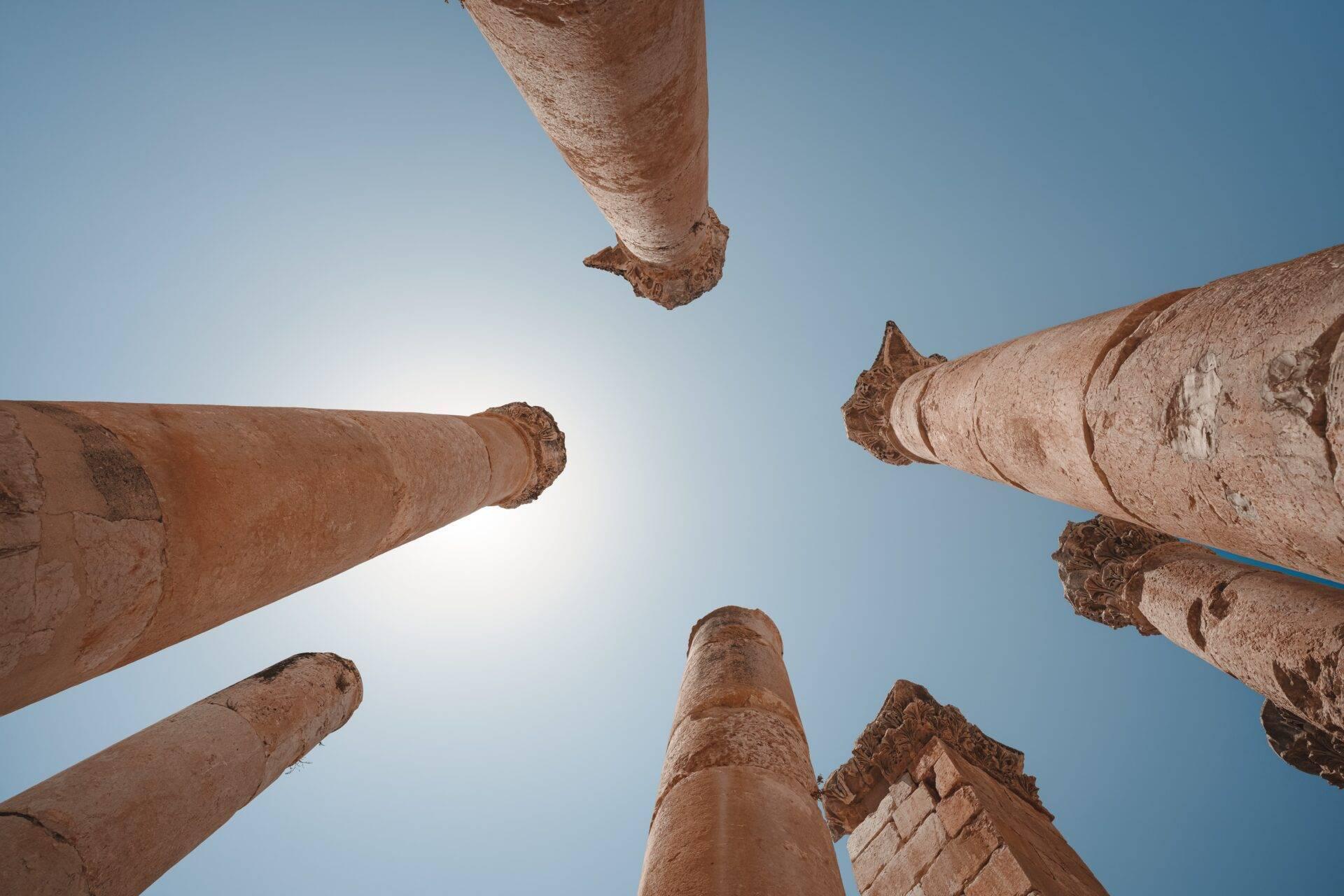 Vue en plongée de colonnes en pierre antiques monumentales contre un ciel bleu dégagé