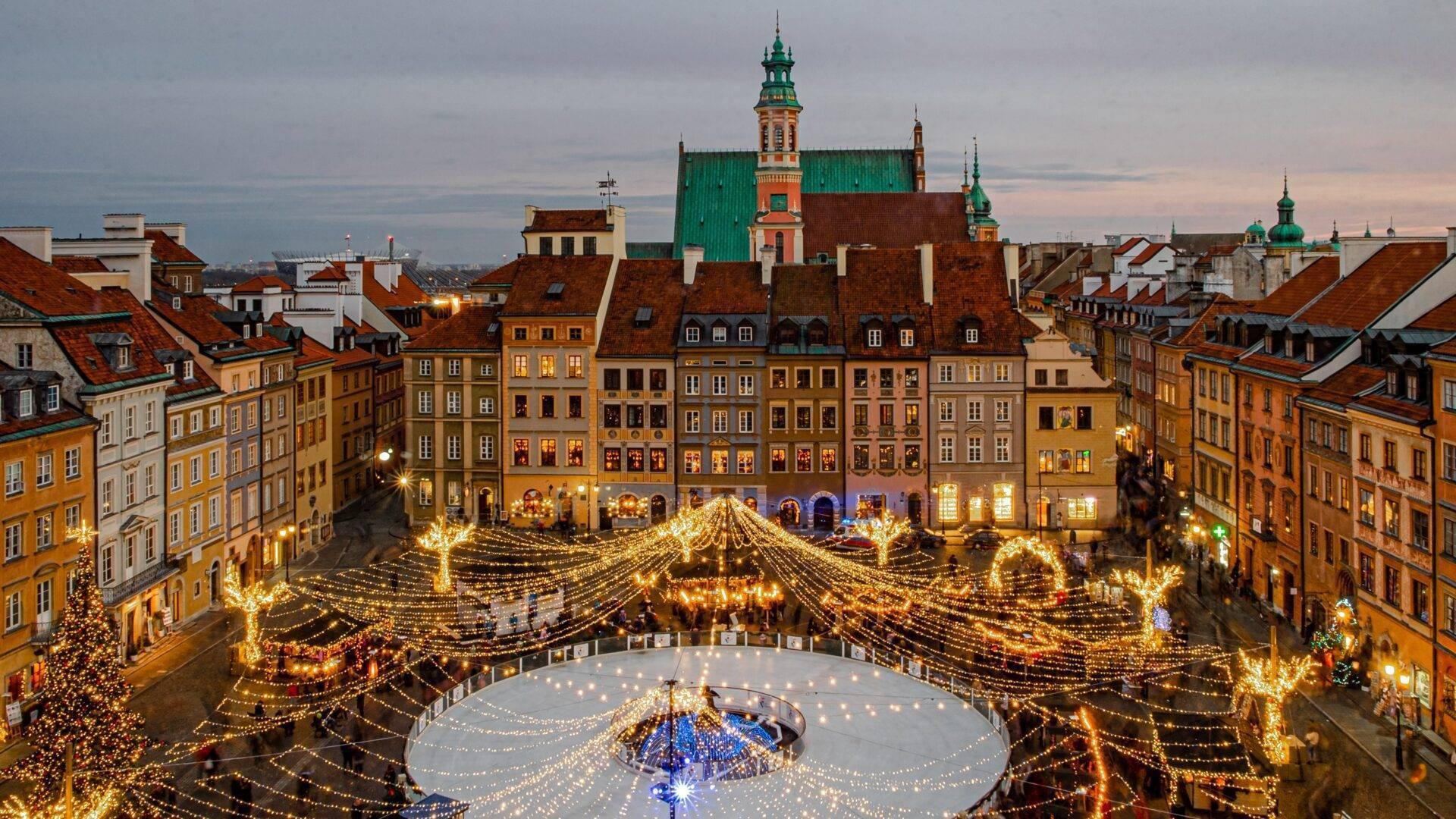Une place historique illuminée de milliers de lumières dorées avec une patinoire centrale et des bâtiments colorés