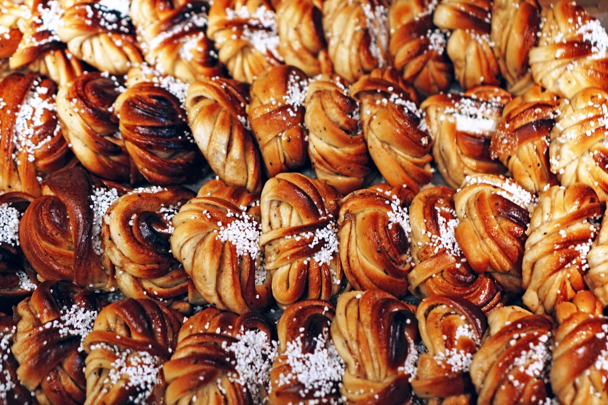 Gros plan sur des pâtisseries feuilletées dorées parsemées de sucre cristallisé, typiques de la pâtisserie scandinave