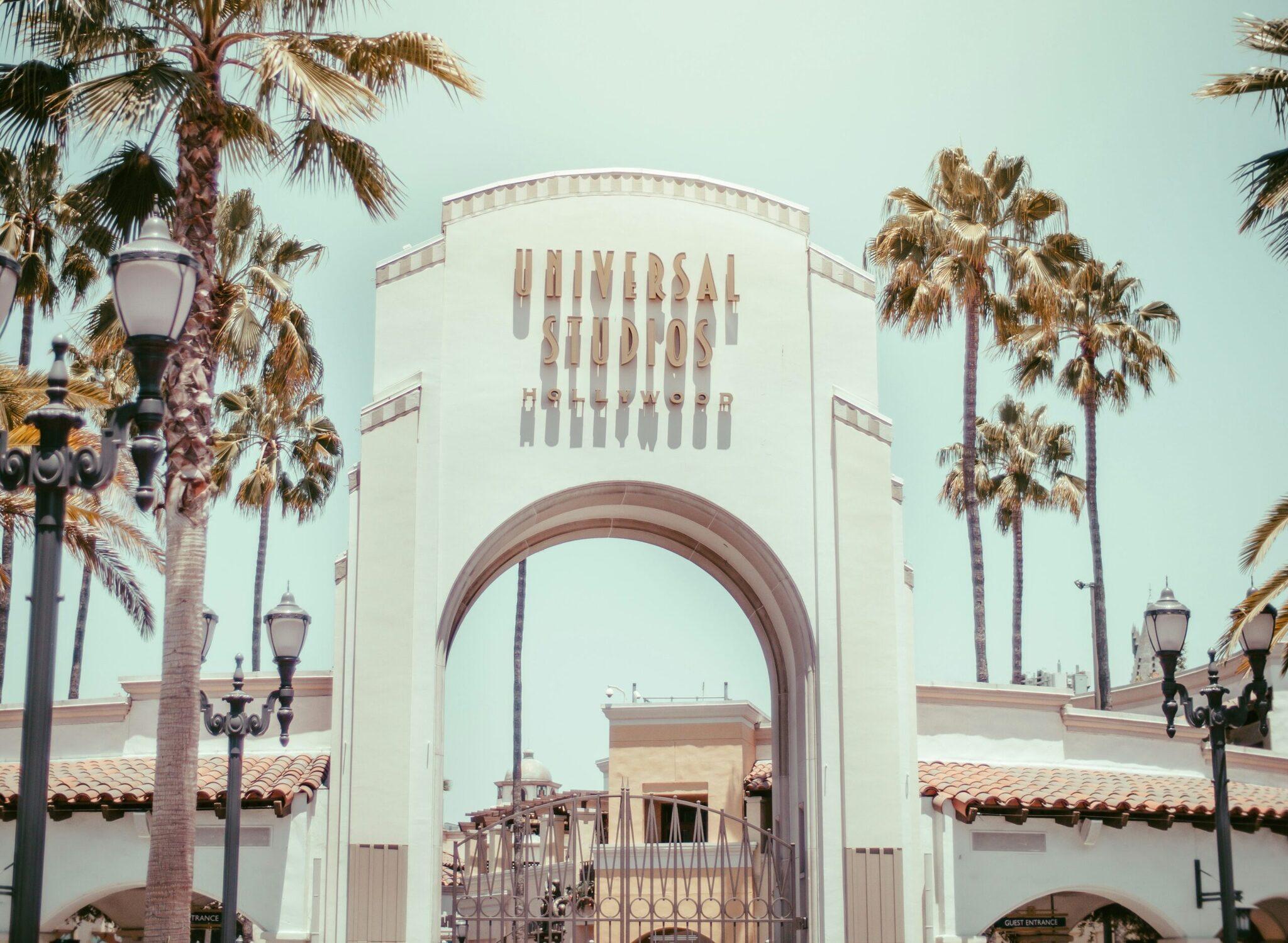 La célèbre arche d’entrée des Universal Studios Hollywood entourée de palmiers sous un ciel dégagé