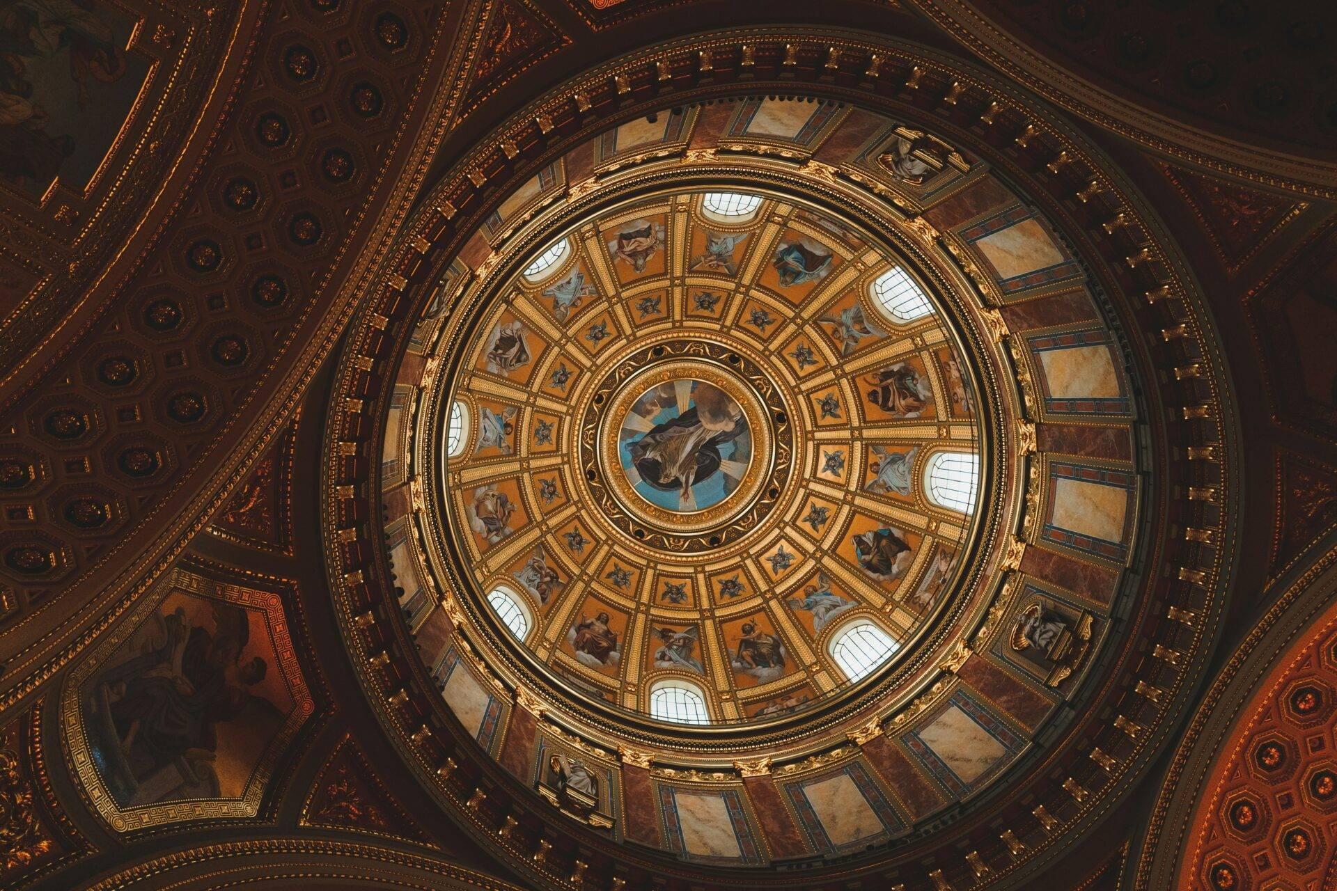 Vue en plongée d’un dôme circulaire richement orné avec fresques, dorures et oculus lumineux dans une architecture néoclassique