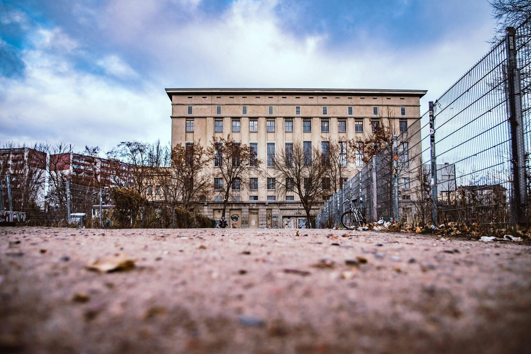 Un terrain de jeu urbain vide bordé de bâtiments historiques en brique et de grillages métalliques